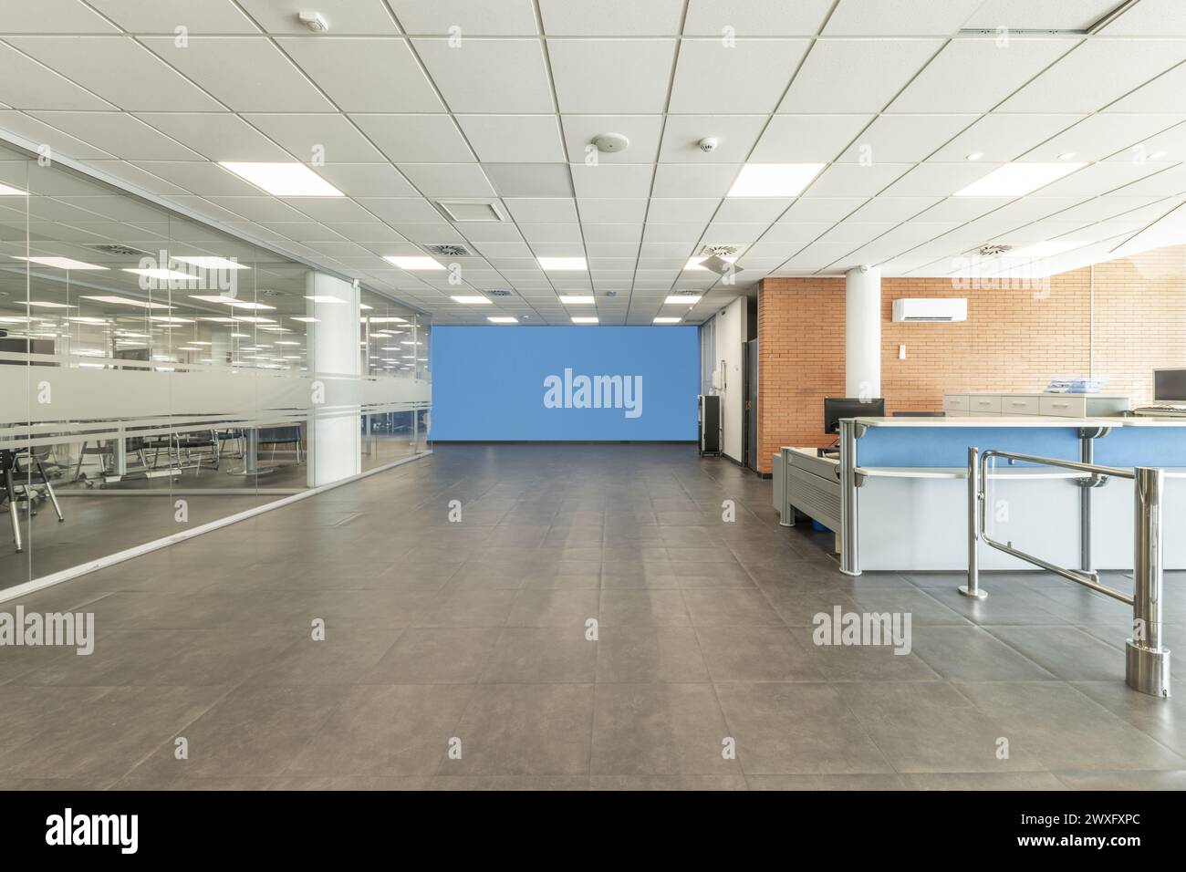 Zone d'accès aux bureaux avec comptoir d'accueil et bureaux dans des aquariums en verre Banque D'Images