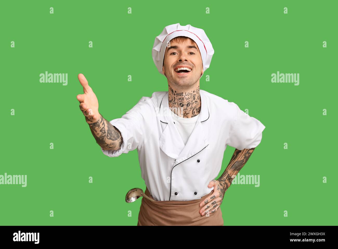 Jeune chef souriant sur fond vert Banque D'Images