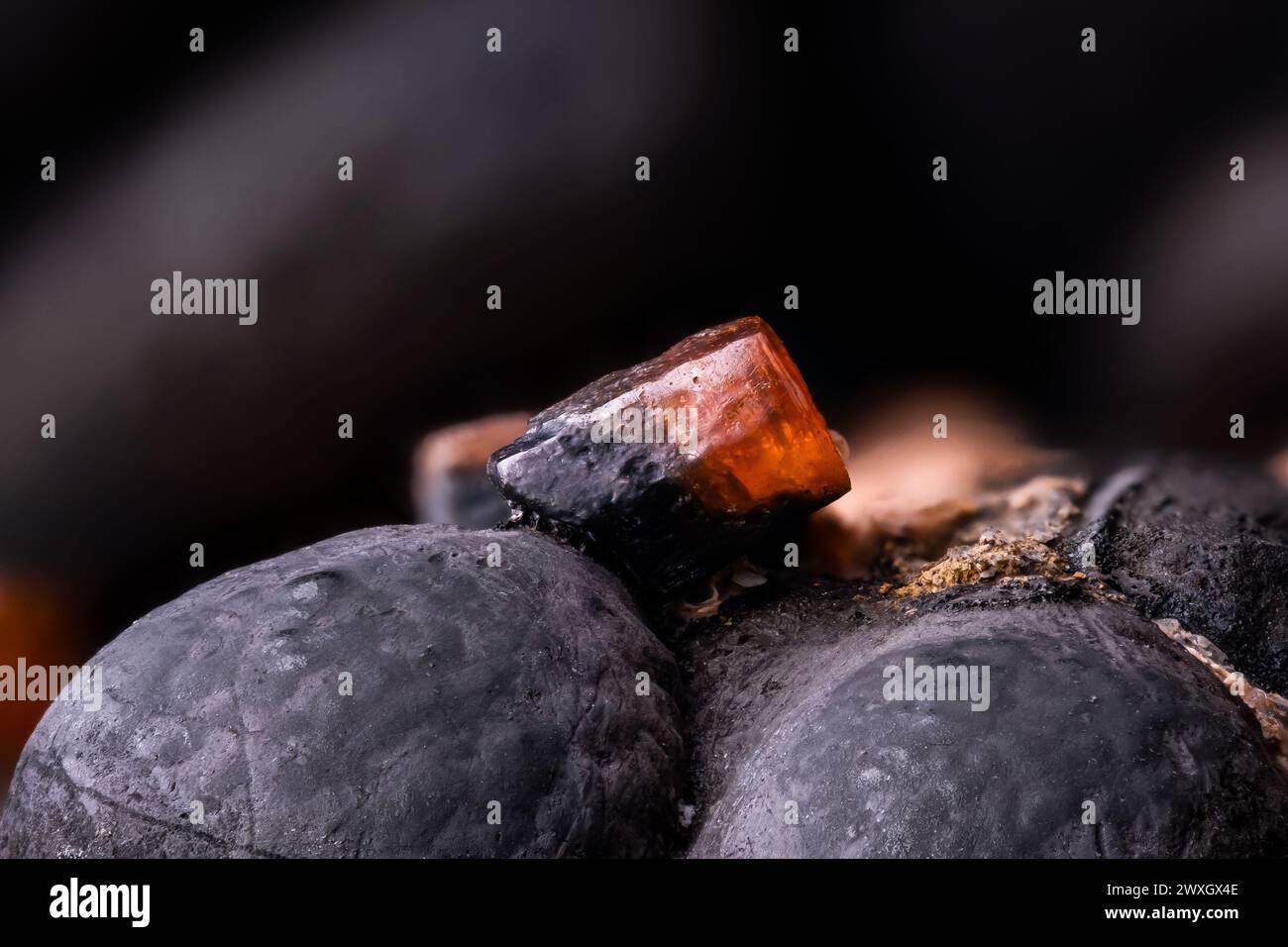 Cristal orange vanadinite sur hématite du Maroc. fond de texture de détail de photographie macro. gros plan brut brut brut semi-précieux non poli Banque D'Images