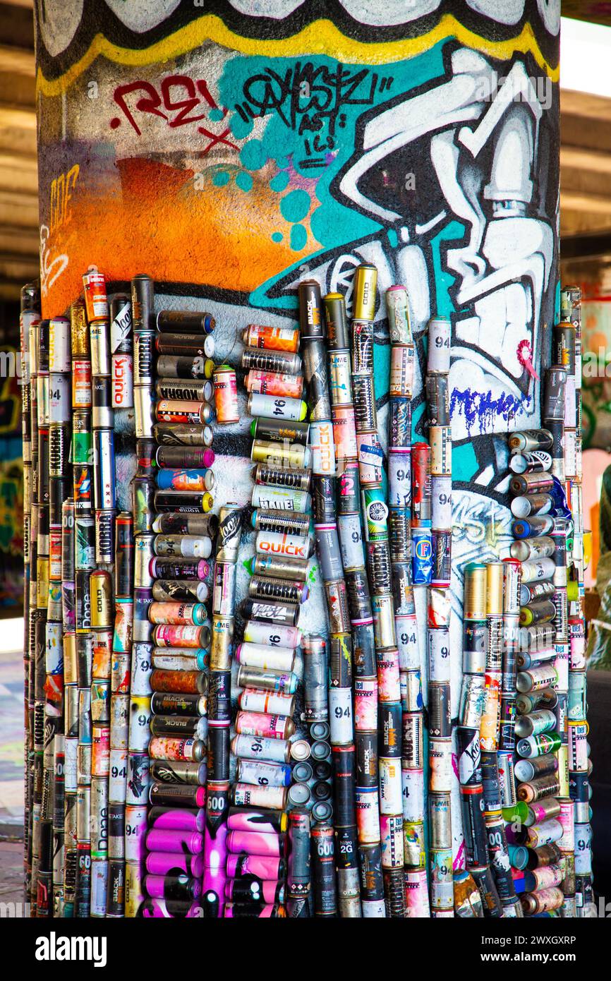 Un pilier décoré de boîtes de peinture en aérosol vides sous un passage supérieur de la route East Cross à Stratford, Hackney Cut, Londres, Royaume-Uni Banque D'Images