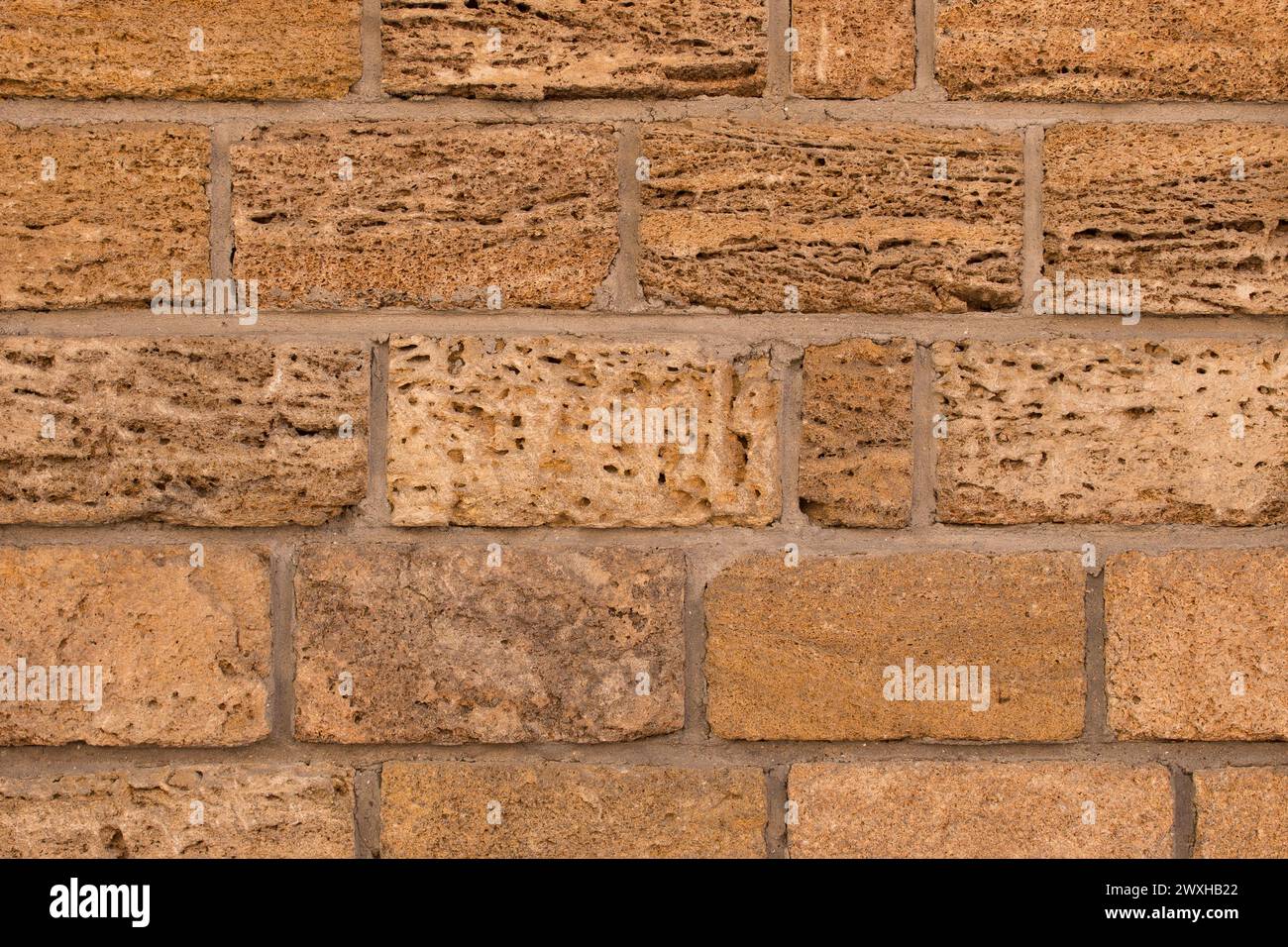 Fond de texture de mur de pierre de sable de blocs de brique marron. Banque D'Images