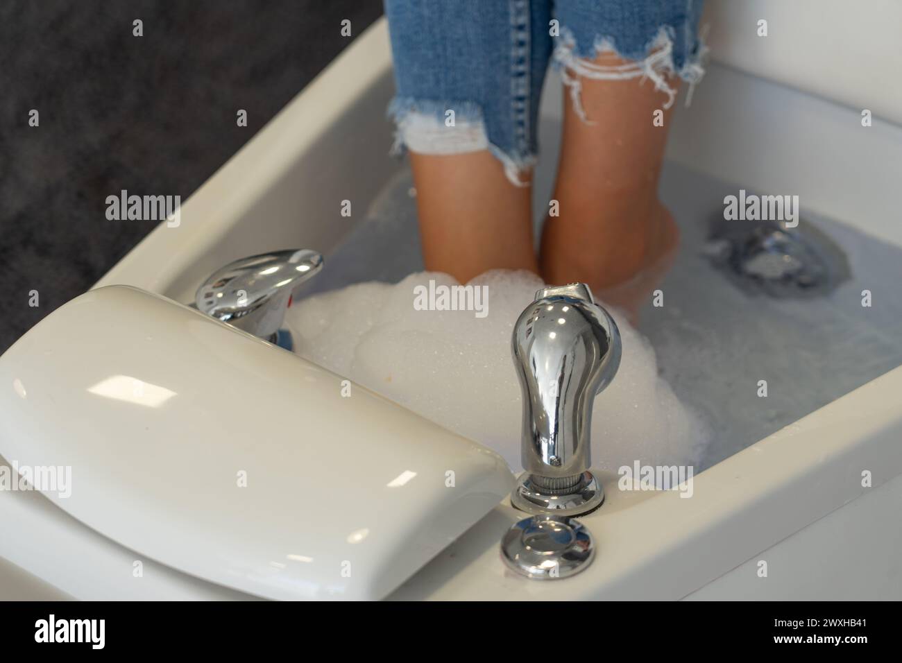 Les pieds des femmes dans une baignoire pédicure dans un centre de beauté Banque D'Images