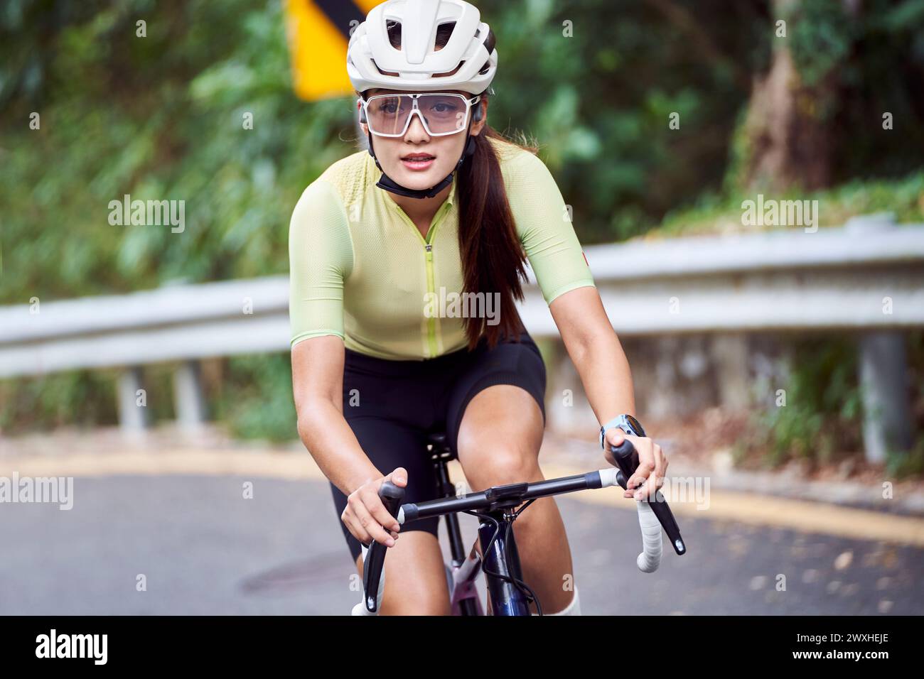 jeune femme asiatique cycliste femme chevauchant le vélo à l'extérieur sur la route rurale Banque D'Images