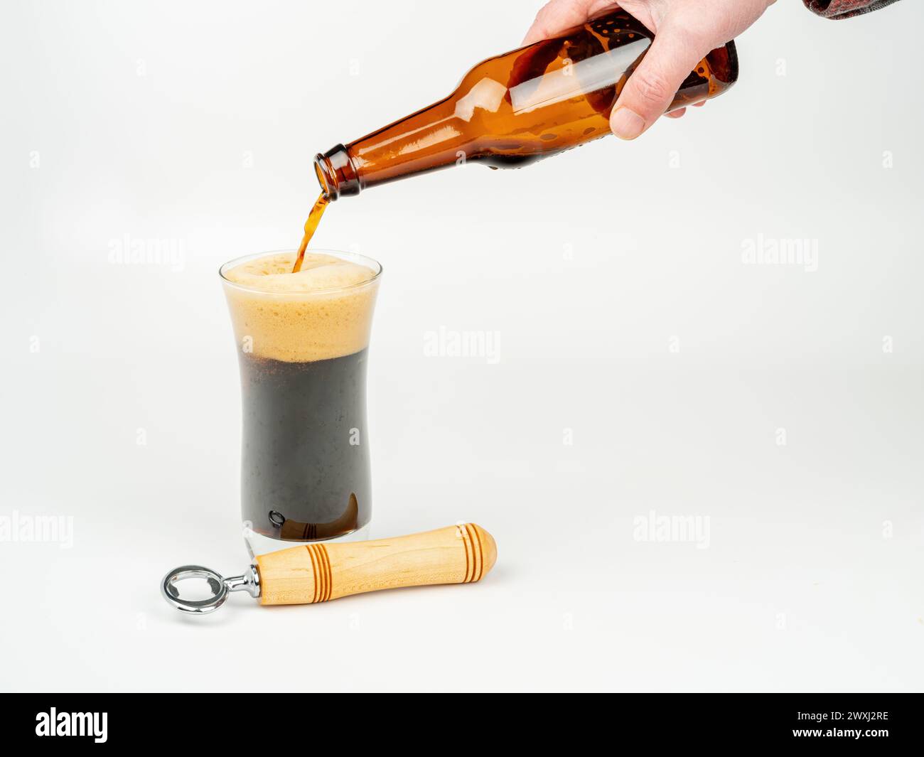 Un verre rafraîchissant de bière est versé dans un verre Banque D'Images