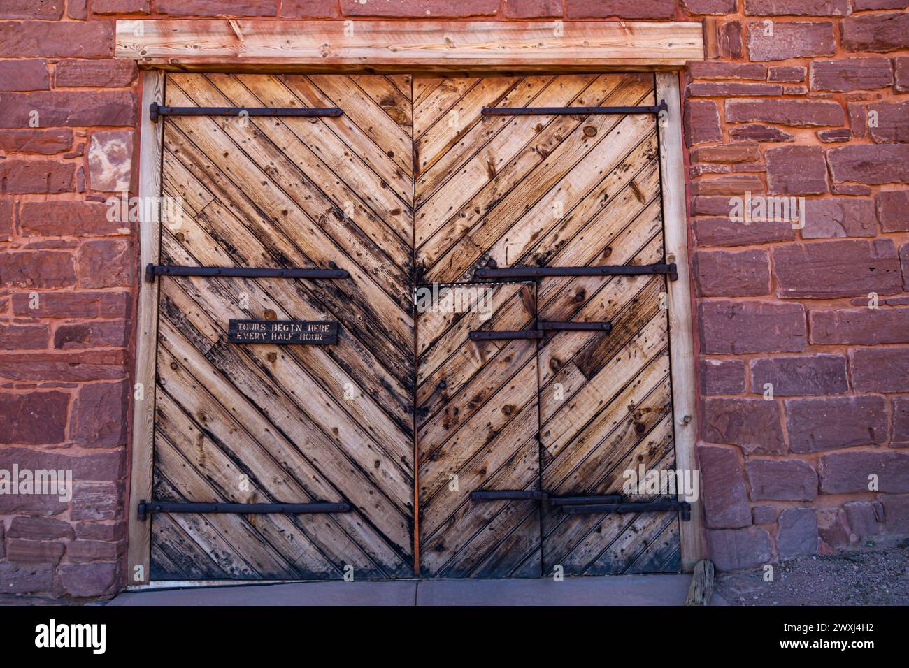 Deux grandes portes en bois dont une contenant une porte plus petite sont l'entrée du Winsor Castle Fort au Pipe Springs National Monument en Arizona. Banque D'Images