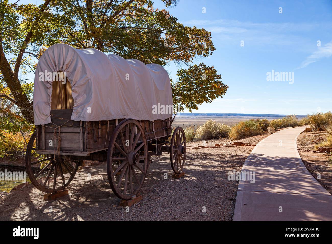 Un vieux wagon couvert en bois exposé sur le site historique de Pipe Springs National Monument à côté d'une passerelle et une vue sur le désert ouvert dans le di Banque D'Images