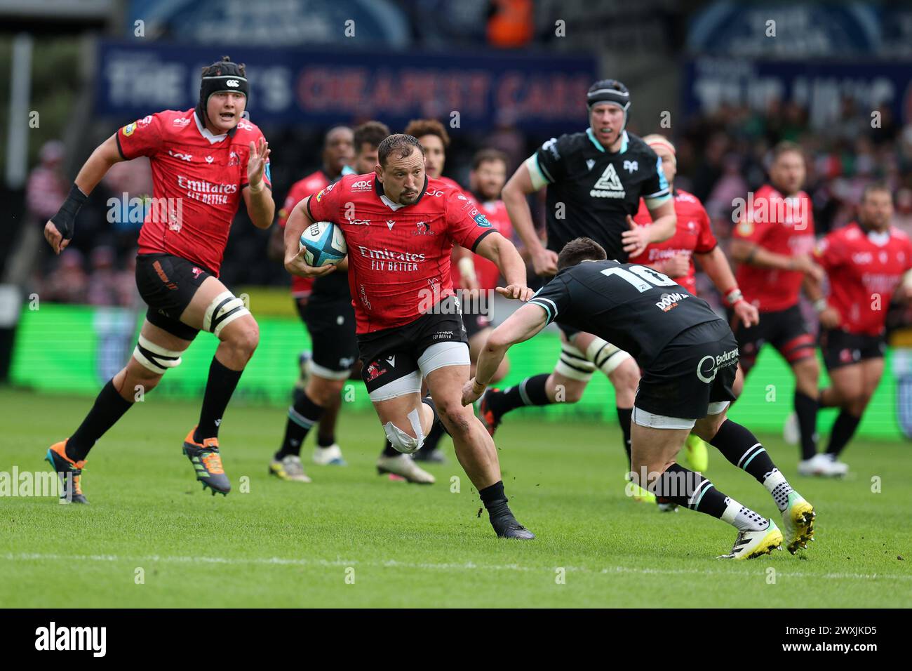 Swansea, Royaume-Uni. 30 mars 2024. JP Smith des Emirates Lions échappe à un tacle d'Owen Williams des Ospreys (R).United Rugby Championship, Ospreys v Emirates Lions au stade Swansea.com de Swansea, pays de Galles du Sud, samedi 30 mars 2024. photo by Andrew Orchard/Alamy Live News Banque D'Images