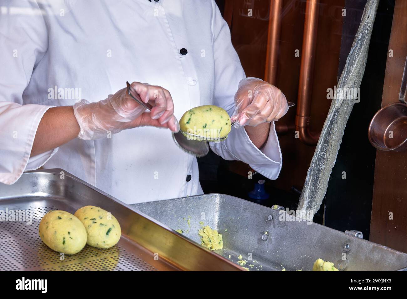 Mains expertes : maîtrise de la fabrication de gâteaux à la morue par une femme Banque D'Images