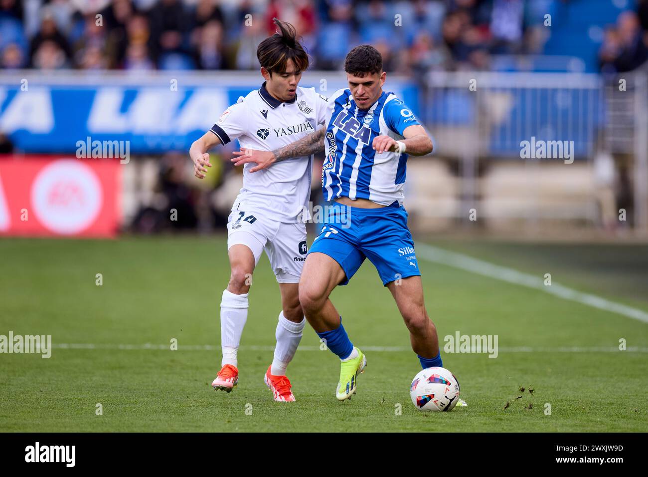 Takefusa Kubo de Real Sociedad concourt pour le ballon avec Javi Lopez de Deportivo Alaves lors du match LaLiga EA Sports entre Deportivo Alaves et Real Sociedad à Mendizorrotza le 31 mars 2024, à Vitoria, en Espagne. Banque D'Images