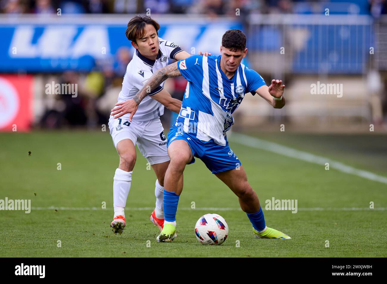 Takefusa Kubo de Real Sociedad concourt pour le ballon avec Javi Lopez de Deportivo Alaves lors du match LaLiga EA Sports entre Deportivo Alaves et Real Sociedad à Mendizorrotza le 31 mars 2024, à Vitoria, en Espagne. Banque D'Images