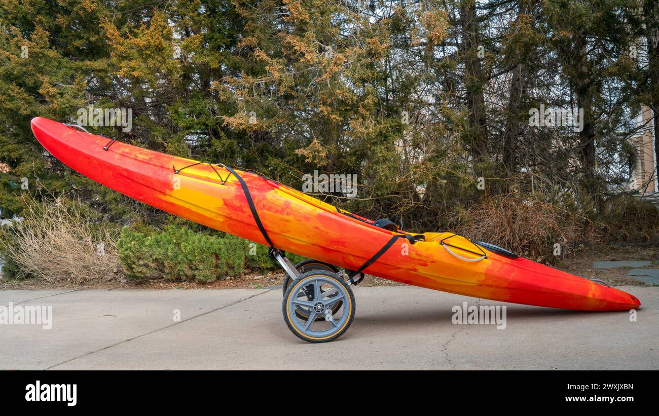 Kayak de rivière colorés sur un panier de pliage dans une entrée de rivière - concept navette Banque D'Images