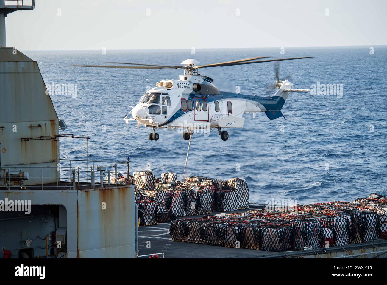 MER DE CHINE MÉRIDIONALE (14 mars 2024) un AS-332 Super Puma, affecté au cargo à sec USNS Charles Drew de classe Lewis et Clark (T-AKE 10), décolle avec du ravitaillement lors d'un ravitaillement vertical avec le porte-avions de classe Nimitz USS Theodore Roosevelt (CVN 71), le 14 mars 2024. Theodore Roosevelt, navire amiral du Carrier Strike Group Nine, mène des opérations de routine dans la zone d'opérations de la 7e flotte américaine. La 7e flotte américaine est la plus grande flotte numérotée déployée vers l’avant de l’US Navy, et interagit et opère régulièrement avec des alliés et des partenaires pour préserver un Indo-PAC libre et ouvert Banque D'Images