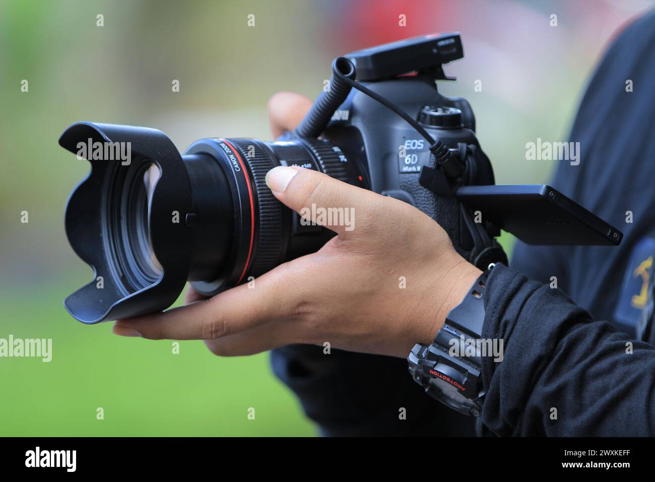 Gros plan d'un appareil photo entre les mains d'un photographe. Canon 6D Mark II Banque D'Images