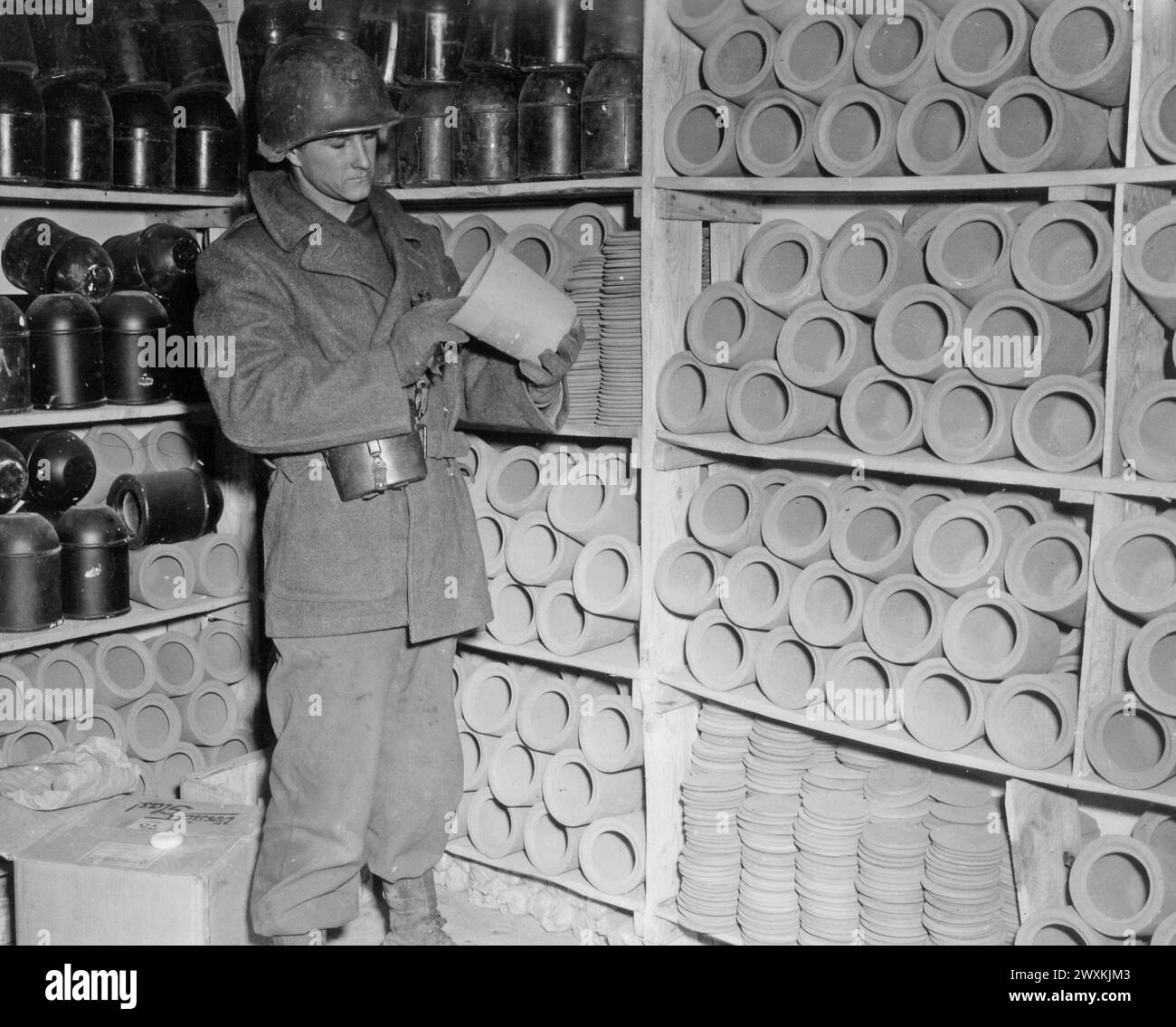 Légende originale : Struthof concentration Camp. Après la crémation, les cendres de la victime ont été placées dans ces petits pots en argile et stockées dans la salle de l'urne. Les cendres pouvaient être récupérées par des proches pour un coût de cinq francs. Région de Natsviller, France, 12/2/44 ici, un soldat regarde une urne. Banque D'Images