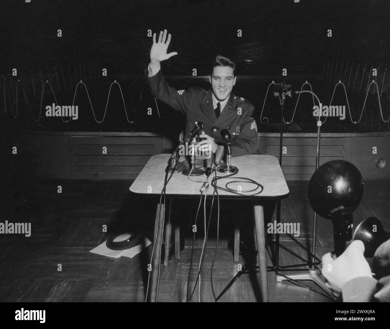 Le Sgt Elvis A. Presley, 32e blindé, 3e Division blindée, Friedberg, dans la vie civile une star du disque et du cinéma, donne sa dernière conférence de presse, en Allemagne avant de retourner aux États-Unis et à la vie civile, dans le club des hommes enrôlés, Ray Barracks CA. Mars 1960 Banque D'Images
