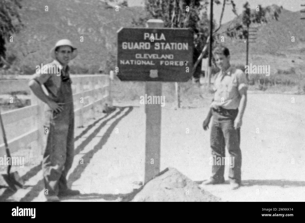 Bande Pala des Indiens de mission : photographie de deux hommes à côté de la station de garde Pala panneau pour la forêt nationale de Cleveland CA. 1936-1942 Banque D'Images