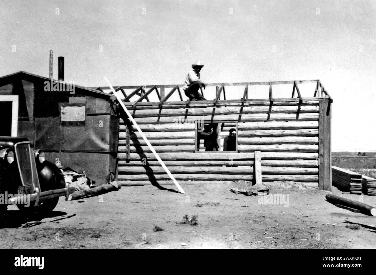 Les hommes travaillant sur un toit pendant la construction d'une cabane en rondins CA. années 1940 Banque D'Images