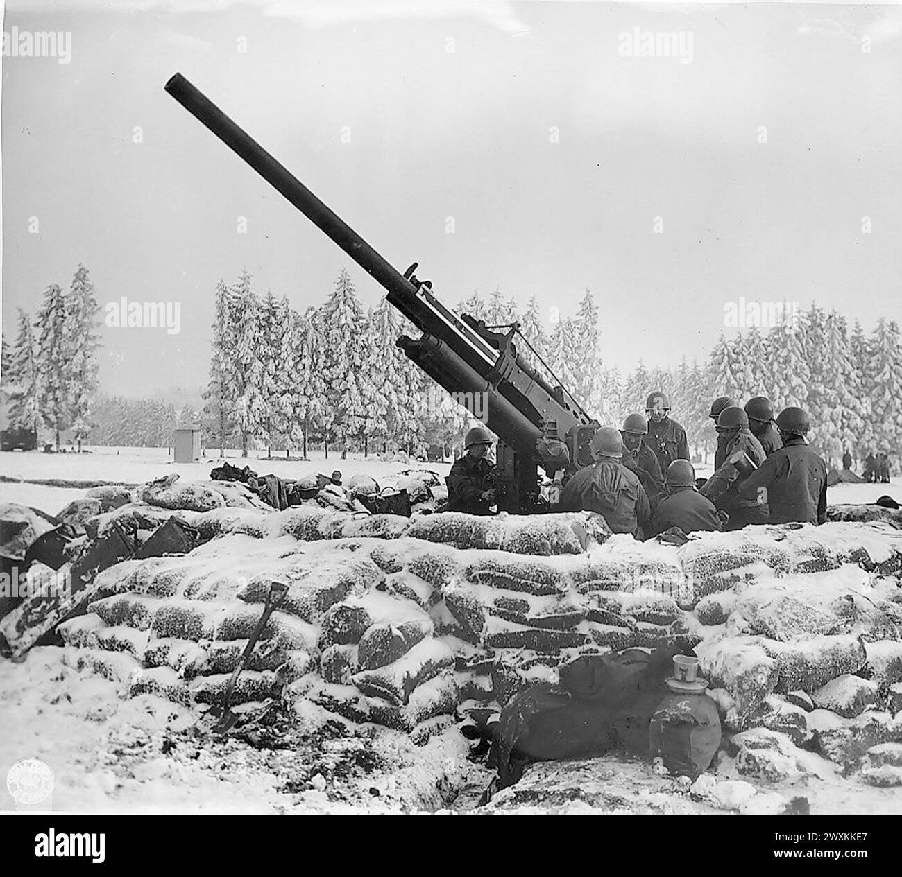 Légende originale : équipage de canon de la «Black Widow», canon anti-aérien de 90 mm creusé à l'extérieur de Bastogne, Belgique, sur le point de tirer sur un avion ennemi aperçu dans la région. Batterie B 217ème Bn (radar) Bastogne. env. 1945 Banque D'Images