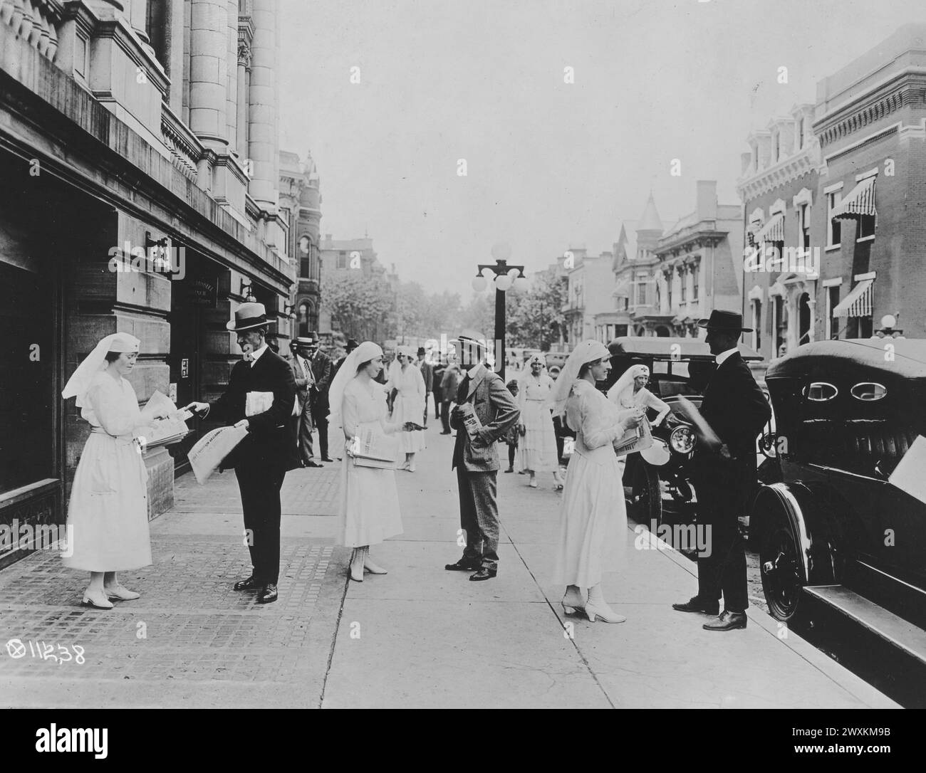 Des infirmières de la Croix-Rouge vendant des journaux dans la rue pour aider à recueillir des fonds pour les efforts de secours de guerre CA. 1919 Banque D'Images