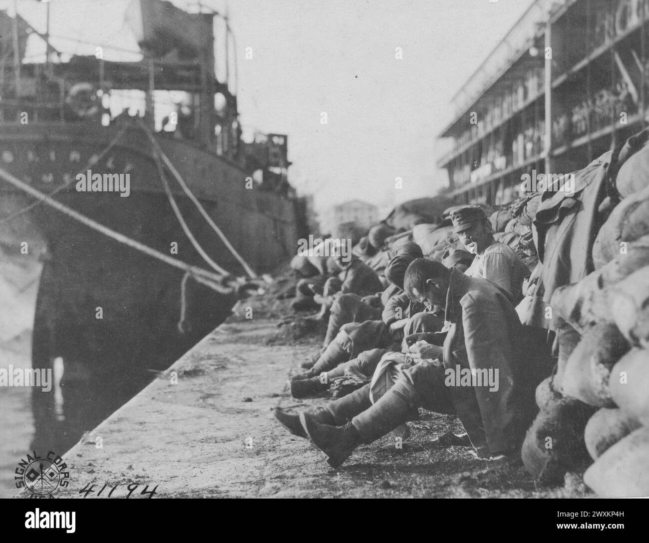 Photos de la première Guerre mondiale : un prisonnier de guerre autrichien assis sur un quai, ramassant les poux de lui-même CA. 1918 Banque D'Images