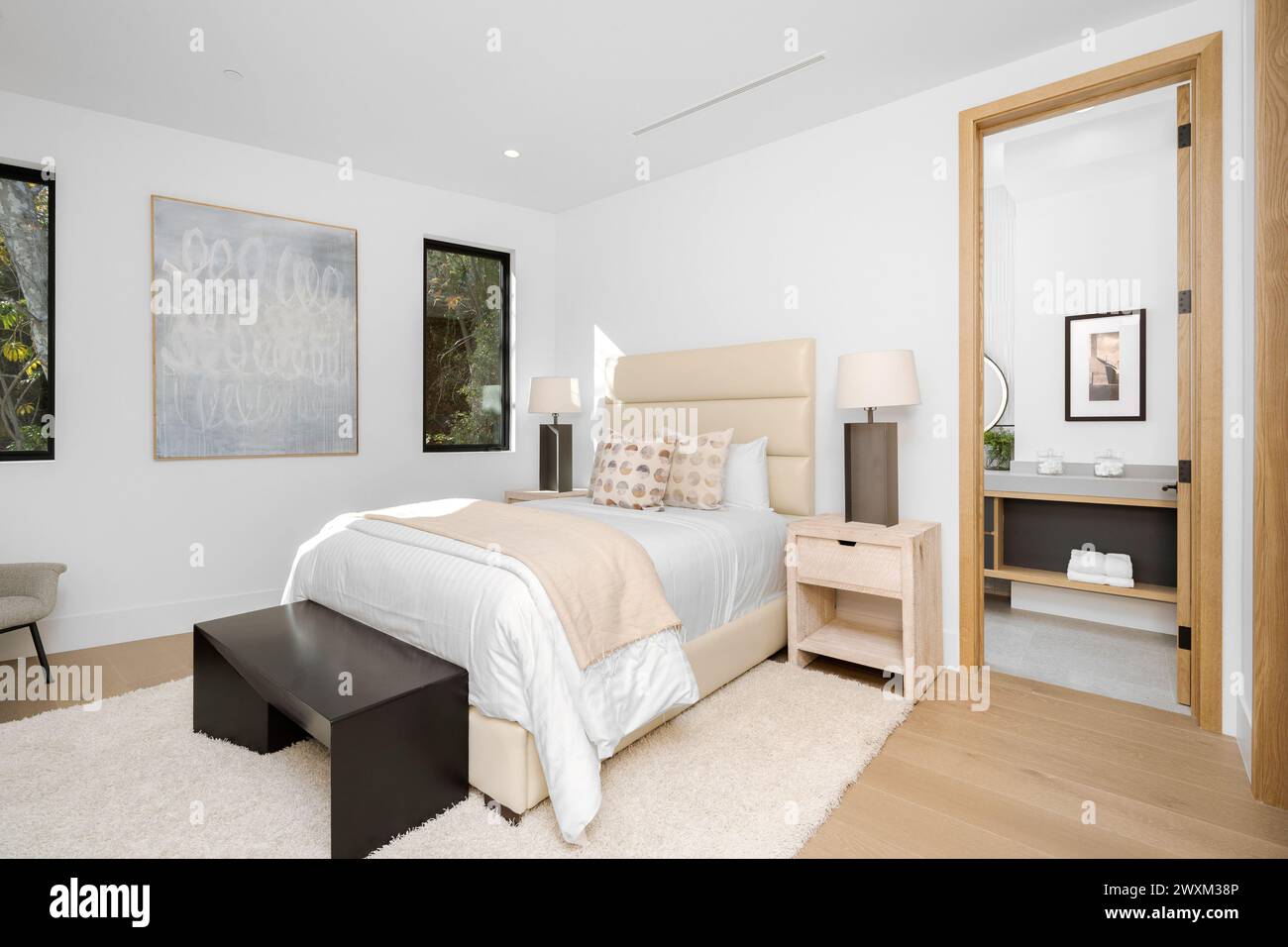 Une chambre avec un lit blanc et commode par une fenêtre. Banque D'Images