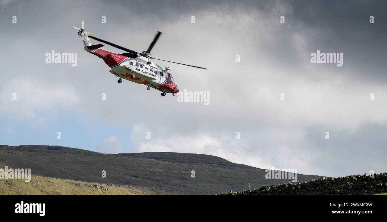 Sikorsky S-92A HM Coastguard SAR hélicoptère en mission de sauvetage aux côtés du Swaledale Mountain Rescue pour assister à une victime dans le Yorkshire Dales, U. Banque D'Images