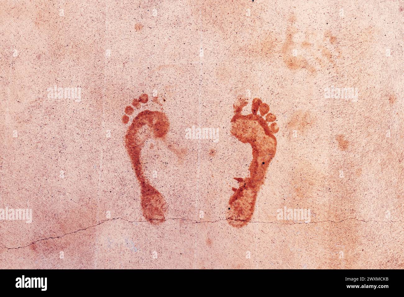 Empreinte humide des pieds mâles sur la surface du sol en béton, vue de dessus Banque D'Images