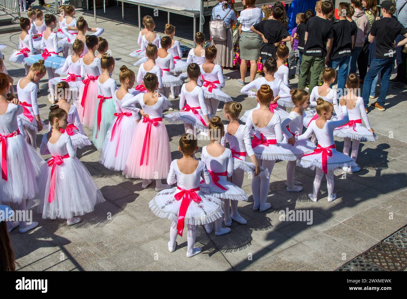 Moscou, Russie - 26 mai 2018 : un groupe de filles dans d'élégantes robes de danse blanches avec des arcs rouges se prépare à se produire lors d'un festival de danse de la ville. Enfant d Banque D'Images