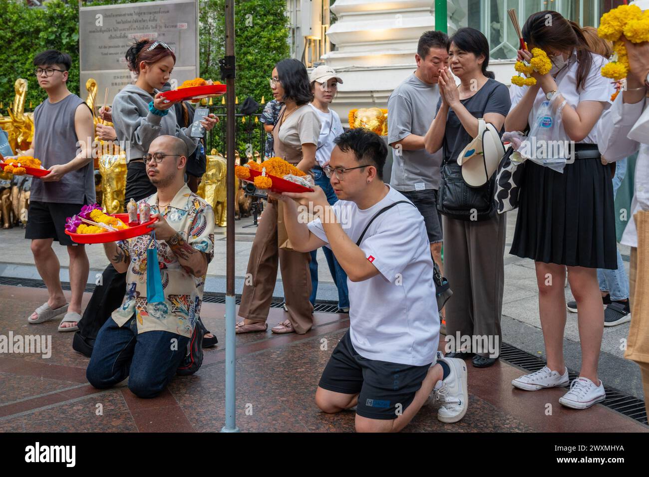 28 mars 2024, Bangkok, Thaïlande : un homme asiatique est vu prier avec un panier d'offrandes entouré par la foule, au sanctuaire Erawan, dans le centre-ville de Bangkok. Le sanctuaire Erawan, dédié au Dieu Brahma, est un site vénéré où les visiteurs de Thaïlande et du monde entier offrent de l'encens, des guirlandes, des fruits et des statues d'éléphants, espérant que leurs souhaits se réaliseront. En outre, le sanctuaire contribue à des causes caritatives, en fournissant un soutien aux hôpitaux et aux organisations dans toute la Thaïlande. (Crédit image : © Nathalie Jamois/SOPA images via ZUMA Press Wire) USAGE ÉDITORIAL SEULEMENT! Non destiné au commerce U Banque D'Images