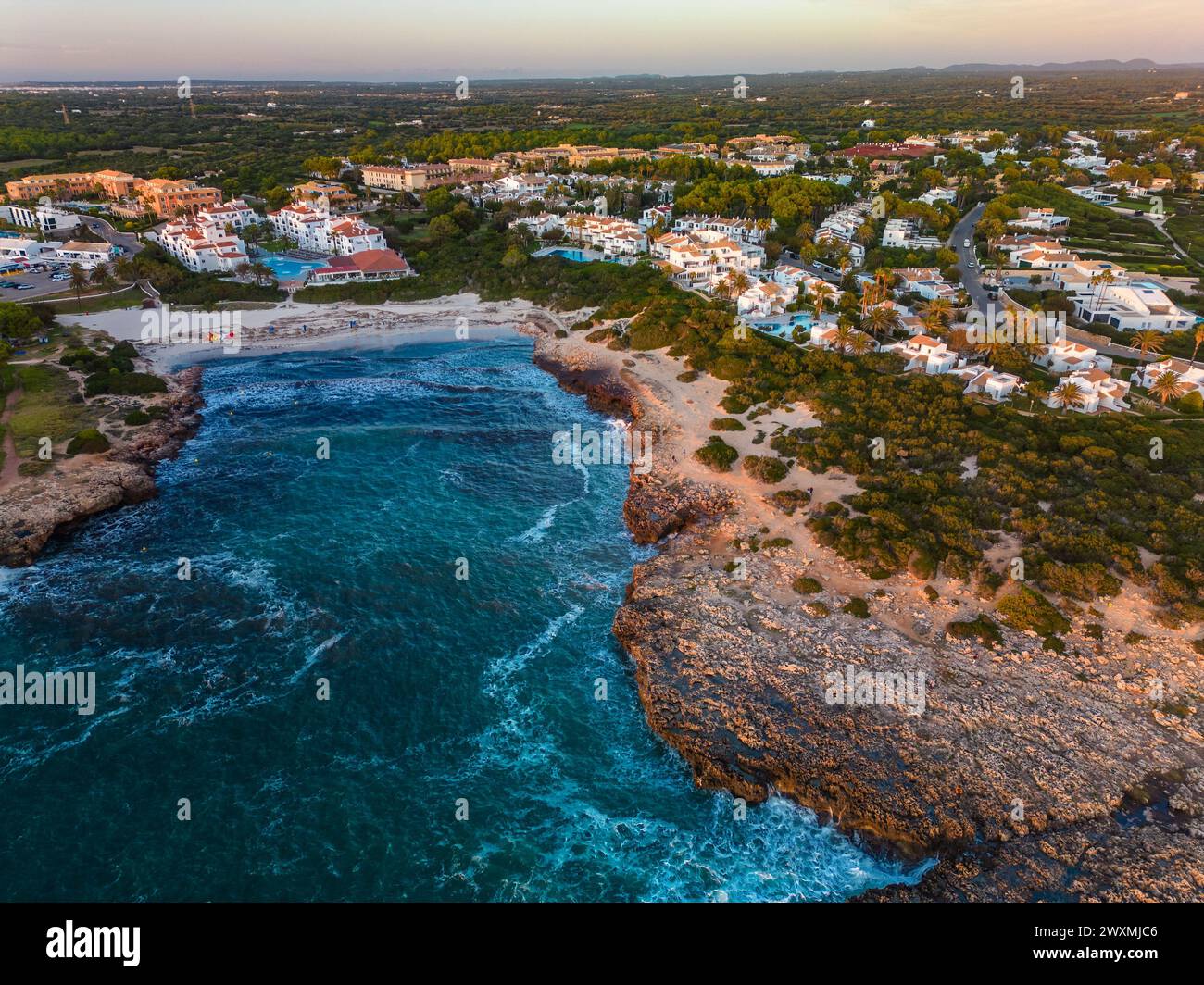 Vue aérienne drone du port, du logement et de la plage de Cala en Bosc sur l'île espagnole de Minorque. Banque D'Images