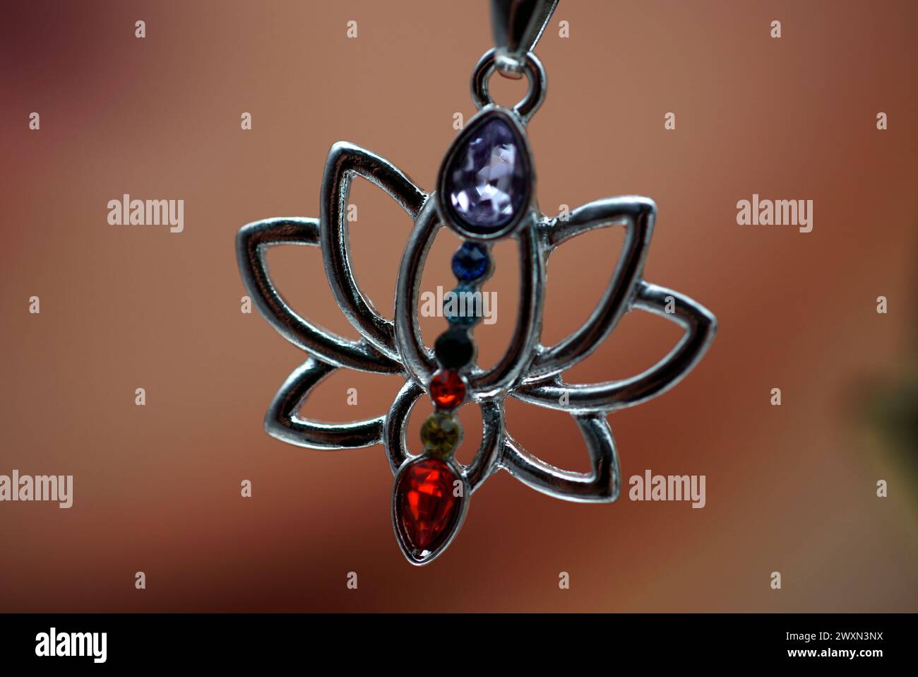 Un pendentif lotus en cristal sur chaîne, main tenue Banque D'Images