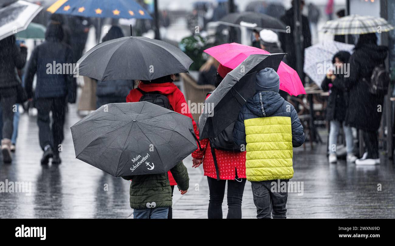 Hambourg, Allemagne. 01st Apr, 2024. De nombreux voyageurs d'une journée se promènent sous des parasols sous la pluie battante à l'installation de protection contre les inondations de Baumwall le lundi de Pâques. Un lundi de Pâques nuageux et pluvieux attend les habitants de Hambourg et du Schleswig-Holstein. Selon une prévision du Service météorologique allemand (DWD), il y aura des pluies prolongées dans le nord à partir de midi. Avec de fortes précipitations de l'Elbe, 30 litres par mètre carré sont attendus dans certaines zones. Crédit : Markus Scholz/dpa/Alamy Live News Banque D'Images