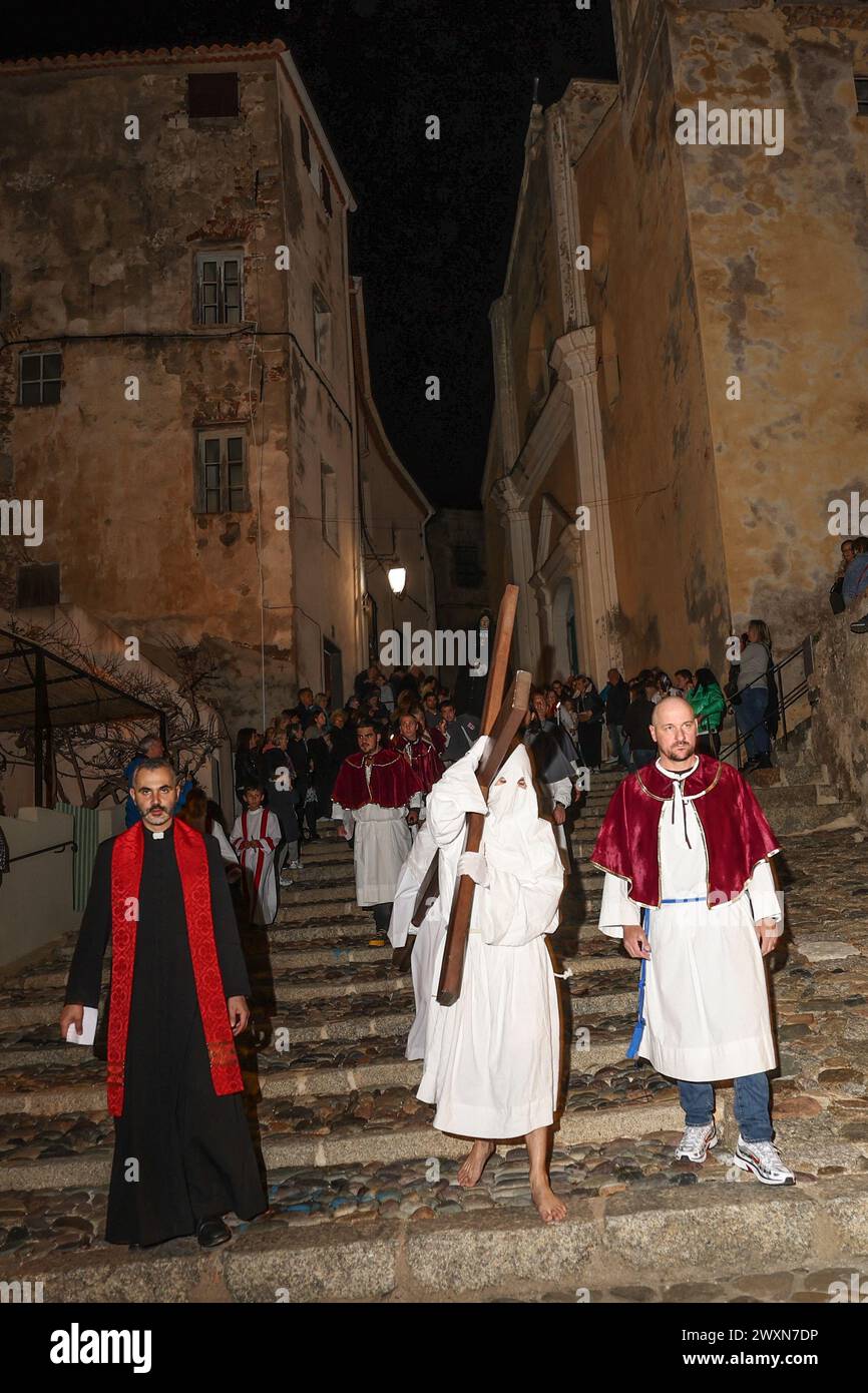 La traditionnelle procession 'Granitula' dans les rues de Calvi, Corse, le vendredi Saint. Cette journée commémore la passion du Christ avec quelques pénitents, et à Calvi il y a une procession particulière. Il part de la cathédrale Saint Jean-Baptiste, dans la citadelle, pour se rendre à l'église Sainte Marie majeure, dans la ville basse. Sur la place de l'église les confrères de parfait Anthony et Erasmus tourne longtemps pour se serrer et former un escargot avant d'agrandir le cercle et de partir à d'autres stations. Pieds nus, le pénitent portant la lourde croix pour reproduire le Calvaire du Christ portant sa croix. Calvi, Cor Banque D'Images