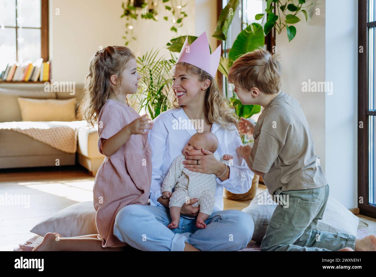 Mère après avoir accouché en tant que reine. Fille donnant à maman une couronne de papier, admiration, amour pour les mères, concept de fête des mères et force des femmes. Banque D'Images