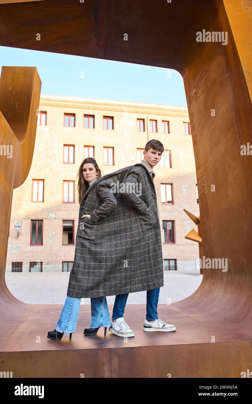 jeune couple partageant un manteau dans la photo d'un artiste Banque D'Images