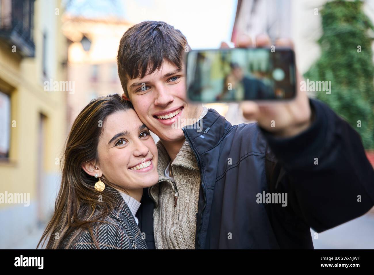 jeune couple prenant un selfie avec leur smartphone dans la ville Banque D'Images