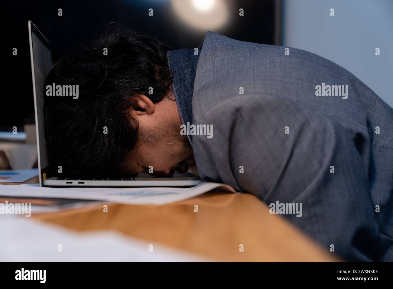 L'homme qui travaillait tard s'est endormi avec son ordinateur portable toujours au travail Banque D'Images