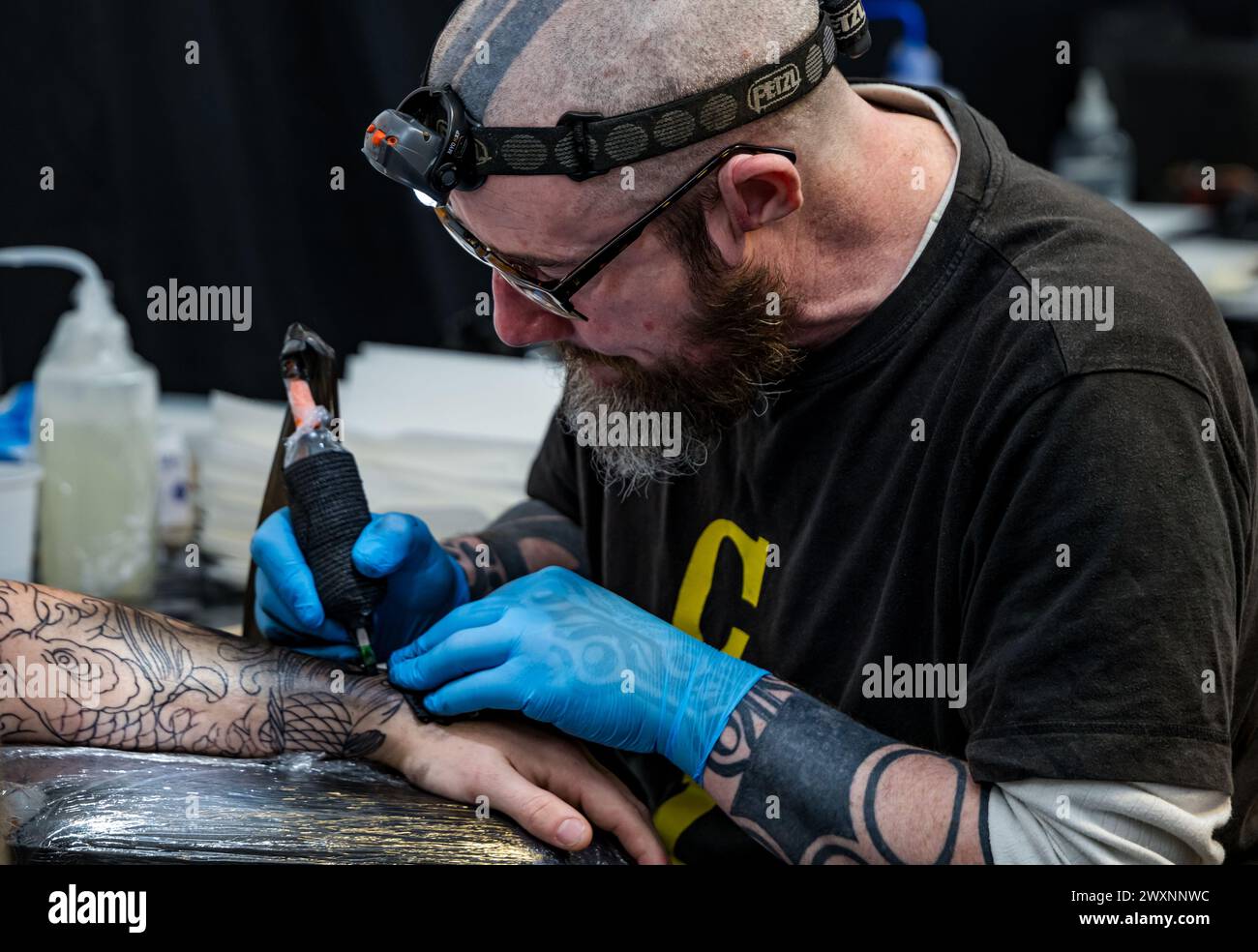 Homme se faisant tatouer un bras à Scottish Tattoo Convention, Édimbourg, Écosse, Royaume-Uni Banque D'Images