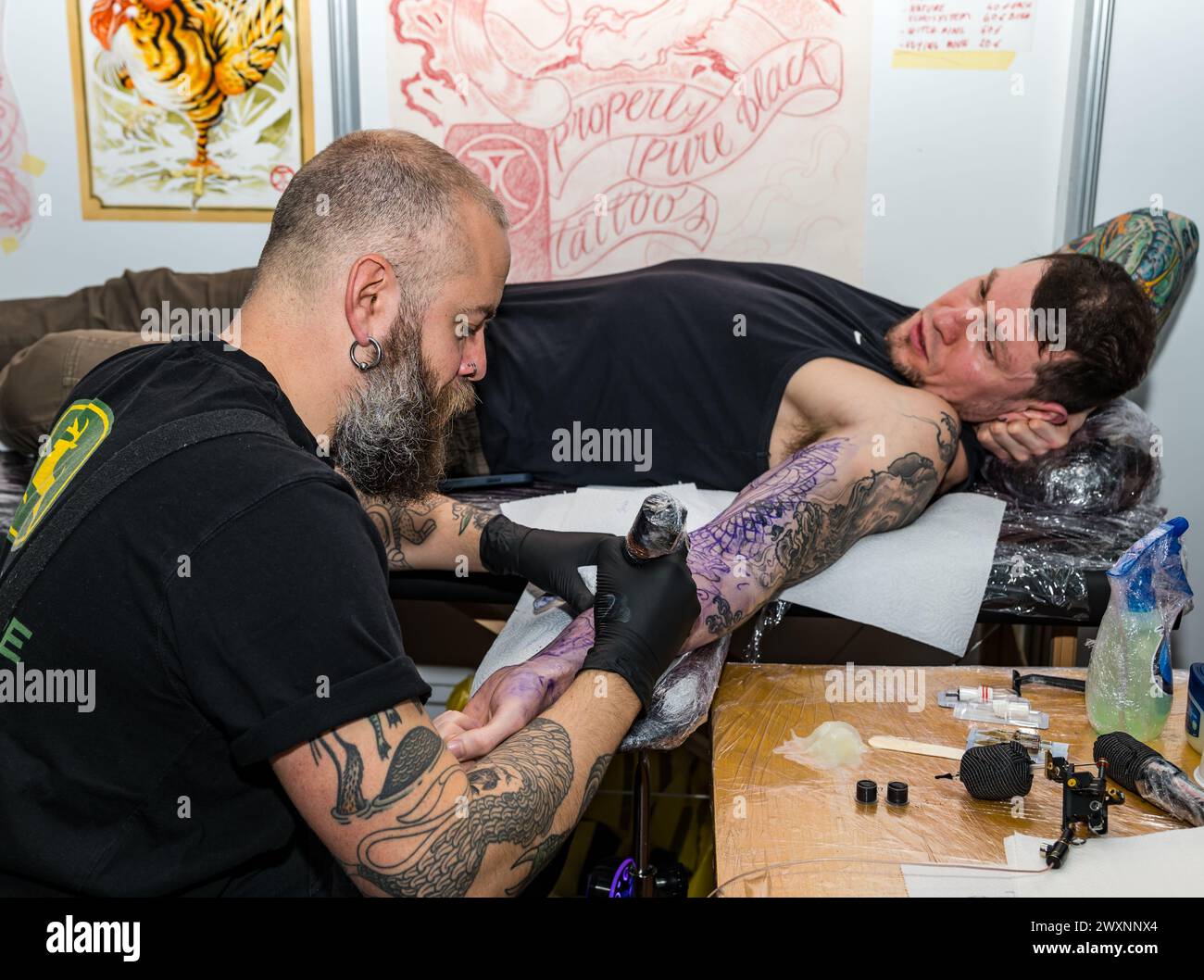 Homme se faisant tatouer un bras à Scottish Tattoo Convention, Édimbourg, Écosse, Royaume-Uni Banque D'Images