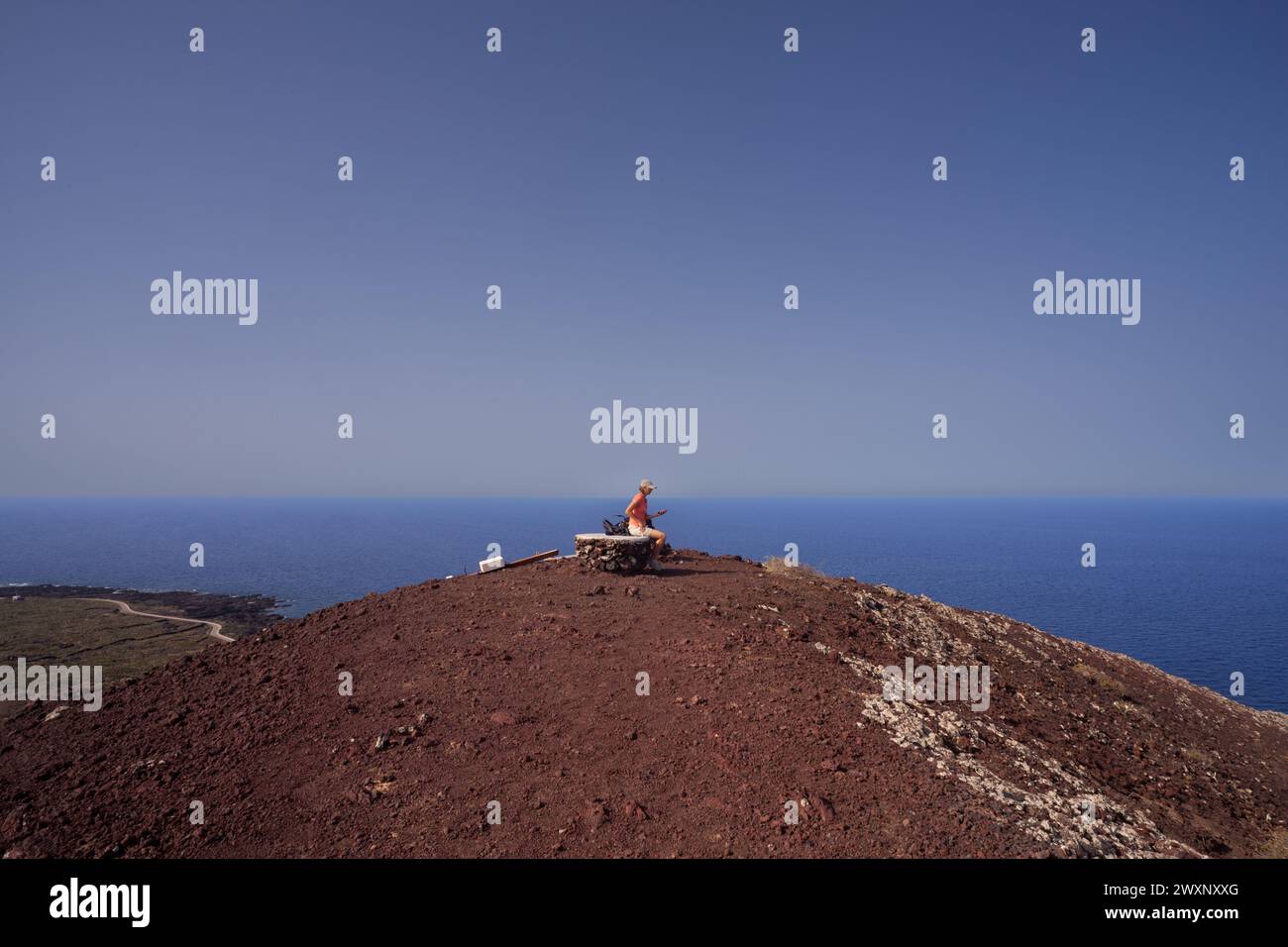 Une femme avec un chapeau regardant la mer du haut du volcan appelé Monte Nero, Linosa. Sicile. Italie Banque D'Images