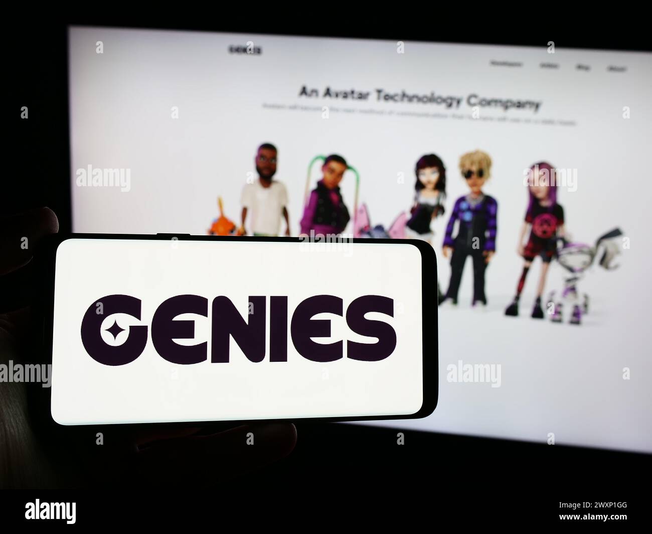 Personne tenant un smartphone avec le logo de la société de technologie avatar américaine Genies Inc en face du site Web. Concentrez-vous sur l'affichage du téléphone. Banque D'Images