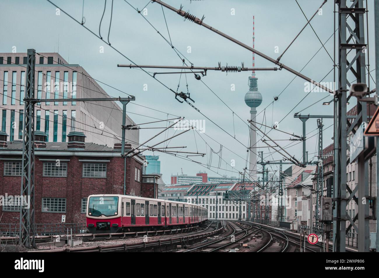 Le train de banlieue ou SBahn de Berlin approche de la gare Friedrichstrasse. Transports en commun à Berlin, maisons typiques visibles et point de repère comme tour de télévision Banque D'Images