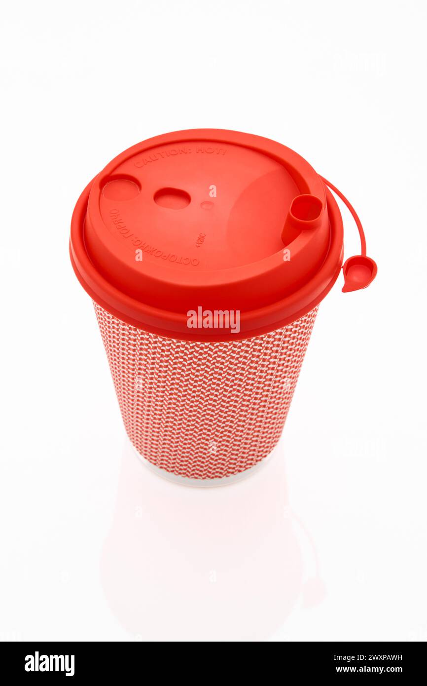 La tasse à café en carton rose avec un couvercle en plastique rouge sur le fond blanc brillant, l'inscription sur le couvercle est soigneusement chaud, transparent Banque D'Images