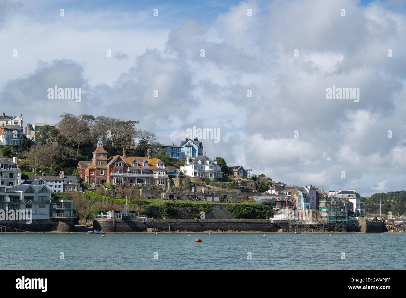 Vue sur Salcombe Yacht Club et la ville environnante, prise de East Portlemouth un jour de printemps avec un ciel bleu et de grands nuages avec une eau calme Banque D'Images