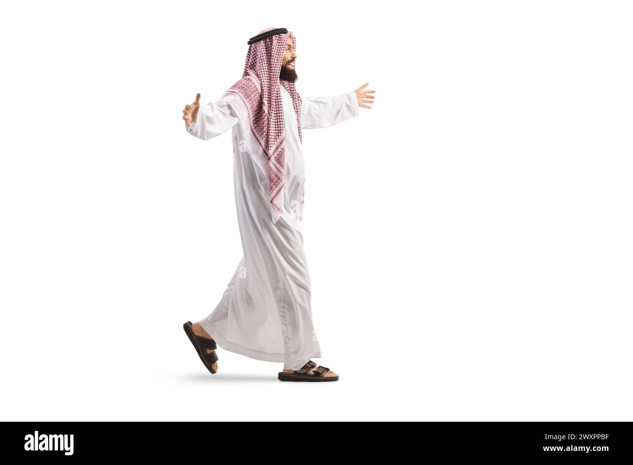 Plan de profil complet d'un homme arabe saoudien dans un thobe traditionnel marchant et saluant avec les mains isolées sur fond blanc Banque D'Images