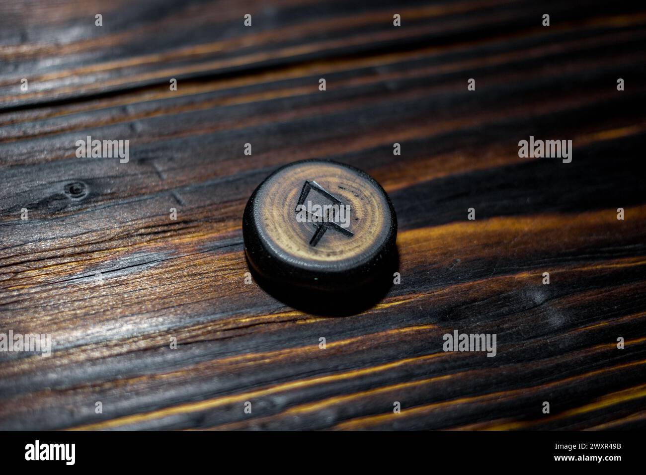Rune Odal (Othala) sculptée dans du bois sur un fond en bois - Elder Futhark Banque D'Images