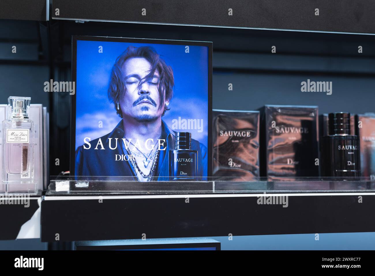 Bangkok, Thaïlande - 3 mars 2024 : parfum Dior sauvage sur l'étagère du magasin avec une affiche avec Johnny Depp. Banque D'Images