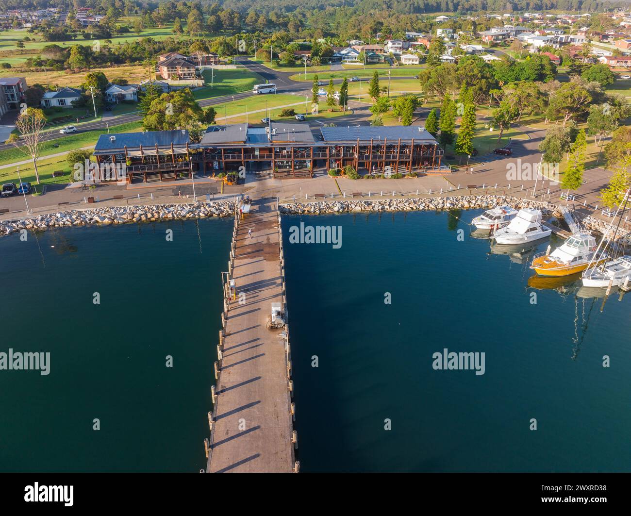 Vue aérienne des bâtiments autour d'une marina côtière et d'un township à Bermagui en Nouvelle-Galles du Sud, Australie Banque D'Images