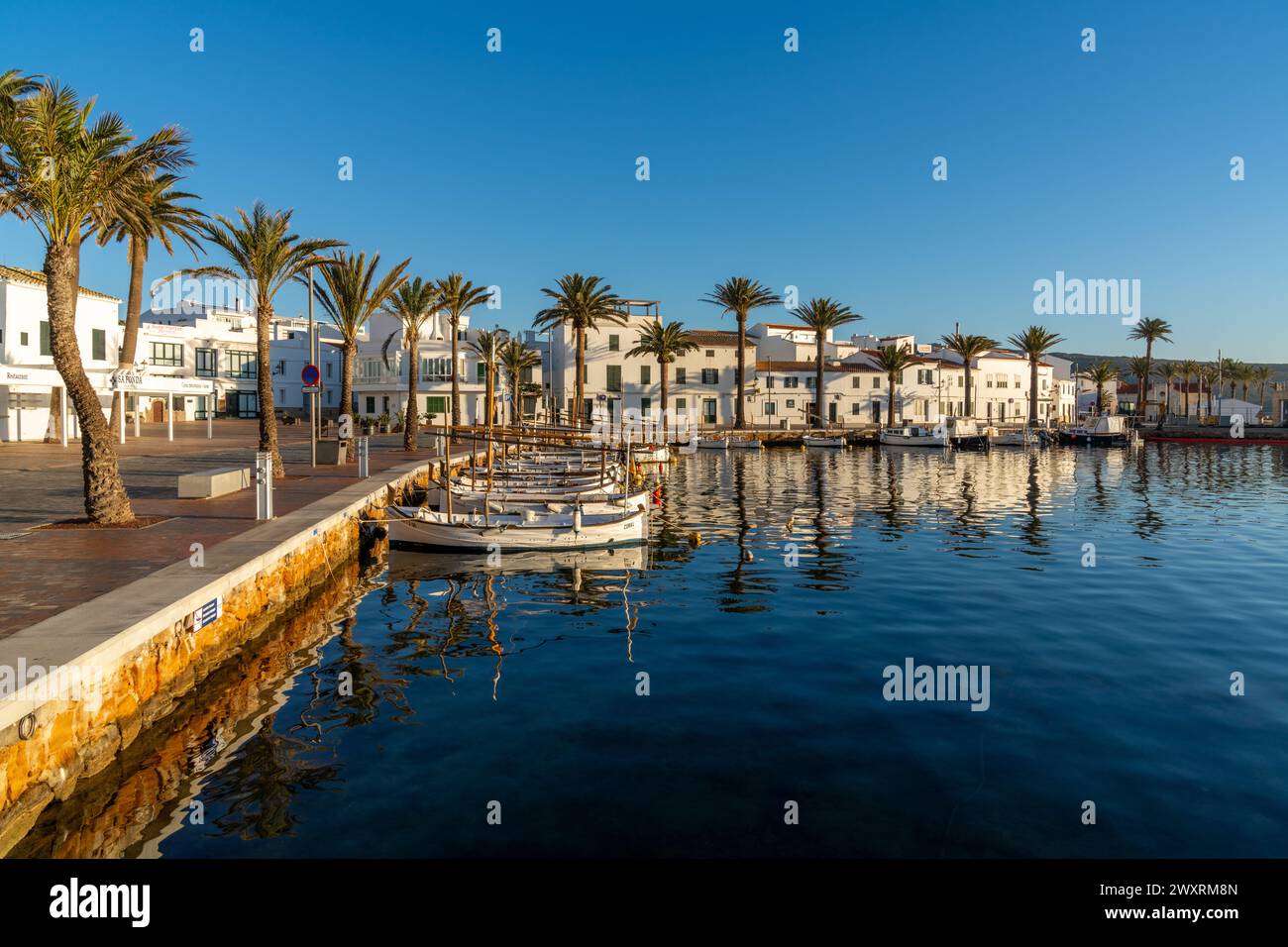 Fornells, Espagne - 25 janvier 2024 : vue sur le village et le port de Fornells dans le nord de Minorque avec des reflets dans l'eau Banque D'Images