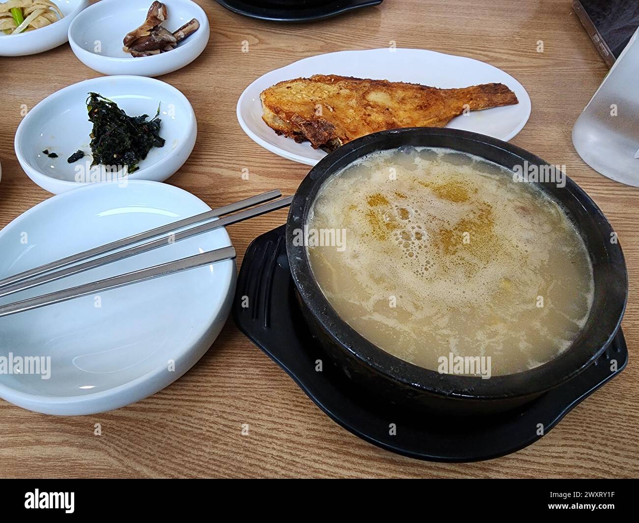 Hwangtae gukbap, ou soupe de riz au pollack séché, célèbre en Corée comme plat haejang (gueule de bois), servi avec de la flet grillée et d'autres accompagnements Banque D'Images